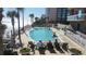 Resort-style pool with ocean view, sunbathers, and palm trees creating a tropical oasis at 1925 S Atlantic Ave # 411, Daytona Beach, FL 32118