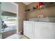The laundry room features a washer and dryer, with shelving above for storage at 2063 Killinger St, Deltona, FL 32738