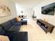 Inviting living room with tile flooring, a large sectional couch, and a wall-mounted television at 2357 Rio Pinar Lakes Blvd, Orlando, FL 32822