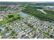 Aerial view showcases the community's homes, landscaping, a retention pond, and nearby woods at 2620 Waterline St, Kissimmee, FL 34743