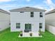 The backyard features lush grass, a sliding glass door, and a quaint, covered patio at 2620 Waterline St, Kissimmee, FL 34743