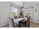 Dining room with table, six chairs, decorative chandelier, and natural light from two windows at 2620 Waterline St, Kissimmee, FL 34743