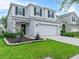 Charming two-story home featuring a well-manicured lawn, gray stucco exterior, and attached two-car garage at 2620 Waterline St, Kissimmee, FL 34743