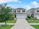 Charming two-story home with a well-manicured lawn, neutral tones, and a two car garage at 2620 Waterline St, Kissimmee, FL 34743