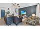 Spacious living room with stylish accent wall, comfortable seating, and a view towards the front entry of the home at 2620 Waterline St, Kissimmee, FL 34743