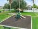 Community playground with play equipment, mature trees and green space at 2620 Waterline St, Kissimmee, FL 34743