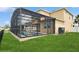 Backyard view featuring a screened pool enclosure and well-kept lawn at 2659 Magpie Way, Sanford, FL 32773