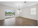 Spacious dining room with wood-like tile floors, sliding glass doors, and elegant chandelier at 2659 Magpie Way, Sanford, FL 32773