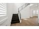 Bright foyer featuring hardwood floors, modern black railings, and staircase with natural light at 2659 Magpie Way, Sanford, FL 32773