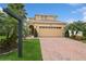 Charming two-story home with brick driveway and lush landscaping featuring mature palm trees at 2659 Magpie Way, Sanford, FL 32773