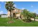 Inviting home exterior with well-manicured lawn, stone accents, and beautiful tropical landscaping at 2659 Magpie Way, Sanford, FL 32773