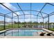 Screened-in pool has relaxing loungers with views of the lake and fountain in the backyard at 2659 Magpie Way, Sanford, FL 32773