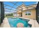 Stunning screened-in pool with table and lounge chairs surrounded by lush landscaping at 2659 Magpie Way, Sanford, FL 32773