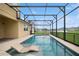 The screened-in pool has integrated loungers, offering a relaxing experience with backyard views at 2659 Magpie Way, Sanford, FL 32773