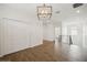 Upstairs hallway features wood-look tile flooring, a contemporary chandelier and white walls at 2659 Magpie Way, Sanford, FL 32773
