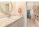 Bright bathroom featuring a vanity with a marble countertop, decorative mirror, and a peek into an adjacent bedroom at 2691 Phillips Rd, Christmas, FL 32709
