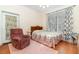 Bedroom with floral bedding, recliner, and bright natural light at 2691 Phillips Rd, Christmas, FL 32709