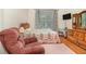 Comfortable bedroom with floral bedding, recliner, and a mounted television at 2691 Phillips Rd, Christmas, FL 32709