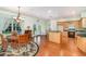 Well-lit kitchen with wood cabinets, adjacent breakfast nook, hardwood floors, and access to backyard at 2691 Phillips Rd, Christmas, FL 32709