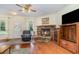 Cozy living room featuring a stone fireplace, hardwood floors, and a comfortable armchair near front door at 2691 Phillips Rd, Christmas, FL 32709
