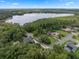 Stunning aerial view of a lakeside home surrounded by lush greenery and featuring a private pool and solar panels at 2750 Lee Shore Loop, Orlando, FL 32820