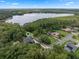 Stunning aerial view of a lakeside home surrounded by lush greenery and featuring a private pool and solar panels at 2750 Lee Shore Loop, Orlando, FL 32820
