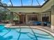 The backyard features a large pool, bar with seating and patio area, all screened in for year-round enjoyment at 2750 Lee Shore Loop, Orlando, FL 32820