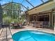 The backyard features a large screened-in pool, outdoor dining, and a bar with seating for entertaining at 2750 Lee Shore Loop, Orlando, FL 32820