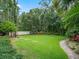 Expansive backyard features lush green grass, mature trees, and a stone walkway, creating a serene outdoor space at 2750 Lee Shore Loop, Orlando, FL 32820