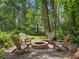 Backyard fire pit with Adirondack chairs offers a cozy outdoor gathering space surrounded by lush greenery at 2750 Lee Shore Loop, Orlando, FL 32820