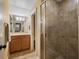 Tiled bathroom featuring a glass shower and vanity with modern lighting fixtures at 2750 Lee Shore Loop, Orlando, FL 32820
