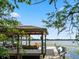 Lakeside boat dock with seating, a boat, and a swing, providing an idyllic spot to enjoy the waterfront views at 2750 Lee Shore Loop, Orlando, FL 32820