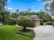 Charming home featuring a manicured lawn, mature trees, and an extended driveway leading to a two-car garage at 2750 Lee Shore Loop, Orlando, FL 32820