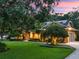 Charming home at dusk with lush landscaping, well-manicured lawn, and warm exterior lighting at 2750 Lee Shore Loop, Orlando, FL 32820