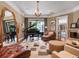 Elegant living room with a grand piano, leather furniture, hardwood floors, and a cozy fireplace in the background at 2750 Lee Shore Loop, Orlando, FL 32820
