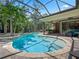 Enjoy the large screened-in pool, sun shelf, and tropical landscaping perfect for relaxation and entertainment at 2750 Lee Shore Loop, Orlando, FL 32820