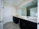 Bathroom featuring double vanity with black cabinets and framed mirror at 2807 Alder Berry Blvd, Ocoee, FL 34761