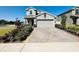 Charming two-story home with neutral color, a brick driveway, and beautiful landscaping at 2807 Alder Berry Blvd, Ocoee, FL 34761