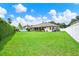 Spacious backyard with lush lawn, mature trees and a white fence for privacy at 289 Laurenburg Ln, Ocoee, FL 34761