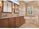 Elegant bathroom features double vanity, soaking tub, and travertine tile surround at 289 Laurenburg Ln, Ocoee, FL 34761