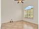 Bright room with neutral-toned tile, ceiling fan, and arched window with plantation shutters at 289 Laurenburg Ln, Ocoee, FL 34761