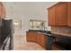 Kitchen with wooden cabinetry, dark countertops, and a view to the screened in patio at 289 Laurenburg Ln, Ocoee, FL 34761