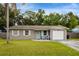 Charming single-story home featuring well-maintained landscaping, a one-car garage, and a welcoming entrance with blue chairs at 2943 Slippery Rock Ave, Orlando, FL 32826