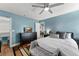 Comfortable bedroom with blue walls, ceiling fan, and a view to the dining area and Primary bath at 3232 Butterfield St, Deltona, FL 32738