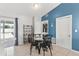 Dining area with tile flooring, blue accent wall, and a view to the outdoor through sliding glass doors at 3232 Butterfield St, Deltona, FL 32738