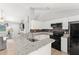 Bright kitchen features granite countertops, white cabinets, and modern black appliances at 3232 Butterfield St, Deltona, FL 32738