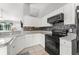 Modern kitchen with white cabinets, granite countertops, and a sleek black oven and microwave at 3232 Butterfield St, Deltona, FL 32738