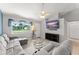 Bright living room featuring a comfortable gray couch, neutral walls, and a large window with natural light at 3232 Butterfield St, Deltona, FL 32738