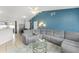 Spacious living room with a gray sectional, a glass coffee table, and open access to the dining area at 3232 Butterfield St, Deltona, FL 32738