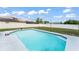 Backyard with an in-ground pool, white fence, and well-maintained landscaping at 3232 Butterfield St, Deltona, FL 32738
